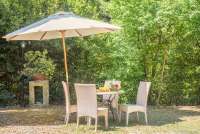 Bildet viser uteplass med spisebord og parasoll utenfor villa Castrum Moriori i Toscana.