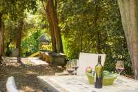 Bildet viser italiensk vin på terrasse med lekeplass i bakgrunnen. Feriehus i Toscana.