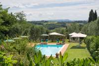 Foto av svømmebasseng og grøntområder på vingården Terra di Toscana i vindistriktet Chianti. 