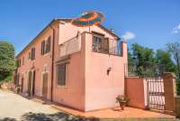 Foto fra veien utenfor feriehuset med inngang til ferieleiligheten Roscianello i Chianti.