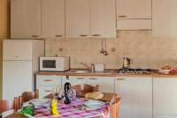 Bildet viser kjøkken og spisebord i ferieleiligheten Vinsanto på vingården Terra di Toscana.