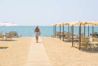 Til strendene ved Middelhavet er det 53 km (40 min.). Bildet viser dame på strandpromenade nært olivengården Vivaio med ferieleiligheter.