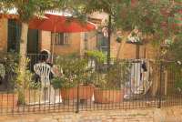 Bildet viser dame under parasoll i en rolig stund utenfor feriehuset Borgo Etruschi i Toscana.