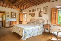 Bildet viser et stort, vakkert soverom med bad på vingården Borgo Etruschi sentralt i Toscana. 