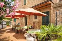 Bildet viser terrasse med bord og parasoller på vingården Borgo Etruschi.