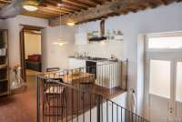 Bildet viser kjøkken og del av stua i ferieleilighet i middelalderlandsby utenfor Pisa.