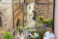 Uteplass med utsikt til vakre steinhus, typisk landsbybebyggelse i Toscana. Hortensia i terracottakrukke. Foto.
