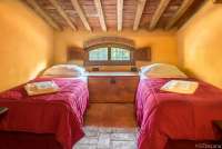 Bildet viser soverom med to senger i ferieboligen Casa Diana i landsby ved Pisa og Lucca.