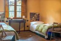 Bildet viser soverom med to senger i ferieboligen Casa Diana i landsby ved Pisa og Lucca.