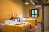 Bildet viser soverom med to store senger i ferieleiligheten Casa Diana ved Pisa.