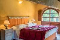 Bildet viser soverom med dobbeltseng i feriehuset Casa Diana med privat basseng og hage ved Pisa.