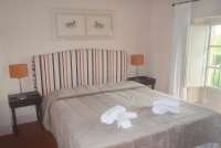 Bildet viser soverom med dobbeltseng i feriebolig nært kysten i Toscana.