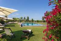 Bildet viser basseng og blomster på feriebosted nært Pisa og strender i Toscana.