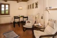 Oppholdsrommet innbyr også til langtidsleie. Oppholdsrommet  i Casetta Livia innbyr også til langtidsleie, også for familie på 4-5 personer. Spisebord og to lenestoler. Tradisjonell toskansk tak.  Bilde