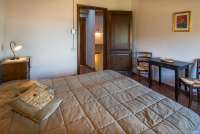 Soverommet i 2. etg. Soverom i øverste etasje i feriehuset. Gang med dør til badet i bakgrunnen. Bilde.