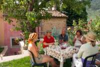 Opp gjennom årene har det vært mange gode samtaler under pæretreet. Spiseplass under pæretreet i hagen. Familegruppe gjester sim leier feriehus i landsby i Toscana. Bilde.