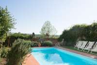 Bildet viser basseng i frodige omgivelser i eksklusiv villa i Toscana.