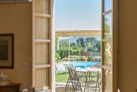 Bildet viser spisestue med utsikt mot basseng og hage ved feriehuset Palazzo Pietro. Huset ligger i Toscana mellom Pisa og Firenze.