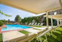 Bildet viser basseng med solstoler i hagen ved feriehuset Palazzo Pietro. Huset ligger i Toscana mellom Pisa og Firenze.