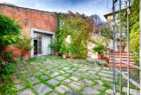 Bildet viser vakker bakgård med blomster i Toscana.