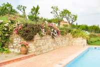 Bildet viser basseng og blomster i feriebolig i landsby i Toscana.