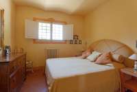 Bildet viser soverom med dobbeltseng i stor villa med utsikt i Toscana.