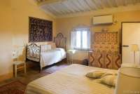 Bildet viser soverom med dobbeltseng og enkeltseng i stor villa med utsikt i Toscana.