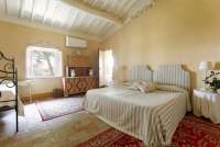 Bildet viser soverom med dobbeltseng i stor villa i Toscana.