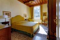 Bildet viser soverom med dobbeltseng i stort feriehus i landsby ved Pisa i Toscana.