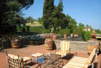 Bildet viser terrasse med utsikt til sypresser i feriehus i Toscana.