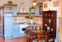 Bildet voser kjøkken med spisebord i feriebolig i landsby i Toscana.