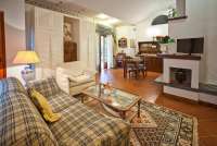 Bildet viser stue med peis i feriehus med basseng i landsby i Toscana.