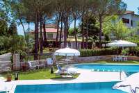 Bildet viser basseng, parasoller og sypresse i barnevennlig feriehus i Toscana.