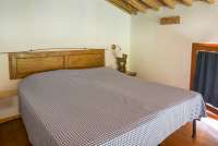 Bildet viser soverom på hems i ferieleilighet på gård med matkurs nært Pisa.