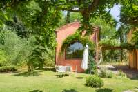 Bildet viser steinhus med ferieleilighet på gård med basseng og frokost i Toscana.