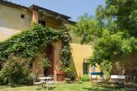 Bildet viser steinhus på olivengård med frokost nært Pisa i Italia.