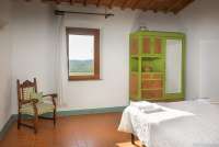 Bildet viser soverom i feriehus med basseng på gård i Toscana.