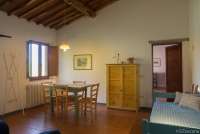 Bildet viser stue med sofa og spisebord i feriehus på olivengård nært Pisa.