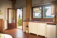 Bildet viser kjøkken med utsikt i feriehus på familievennlig gård ved Pisa i Toscana.