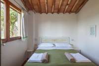 Bildet viser soverom med utsikt i feriehus på barnevennlig gård nært Pisa.