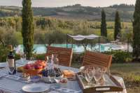 Bildet viser spisebord i hagen ved bassenget på familievennlig feriebosted i Toscana.