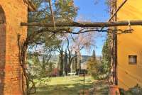 Bildet viser uteplass under pergola på olivengård med ferieleiligheter i Toscana.