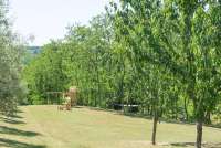 Bildet viser gressplener og trær på stor, privat eiendom nært feriehuset Artemisia.