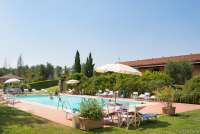 I bakgrunnen er huset med de 10 suitene. Bildet viser basseng på vingård med utleie av rom midt mellom Pisa og Firenze.