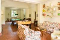 Bildet viser stue med biljardbord i villa til utleie ved Pisa i Italia.