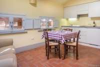 Bildet viser kjøkken og spisebord i ferieboligen Baciamano på vingård i Toscana.