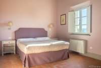 Bildet viser soverom med dobbeltseng i ferieleiligheten Sangiovese på vingård i Toscana.