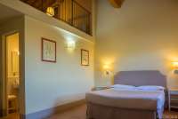 Bildet viser soverom med hems og bad i feriebolig på vingård ved Pisa i Toscana.