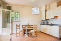 Bildet viser oppholdsrom med kjøkken i ferieleiligheten Nido på vingården Borgo Etruschi. Formidlet av SiToscana.