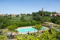 Bildet viser basseng med utsikt mot toskansk landsby.